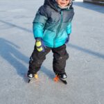 Child skating on a outdoor ice rink.