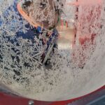 A child behind a frost covered piece of playground equipment.