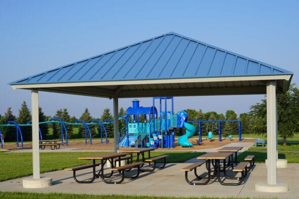 Picnic shelter with four tables at Horizon Park with playground in the background