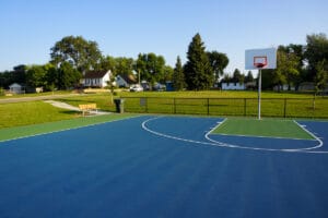 basketball court and a park bench and trail next to it at 23rd St. Park