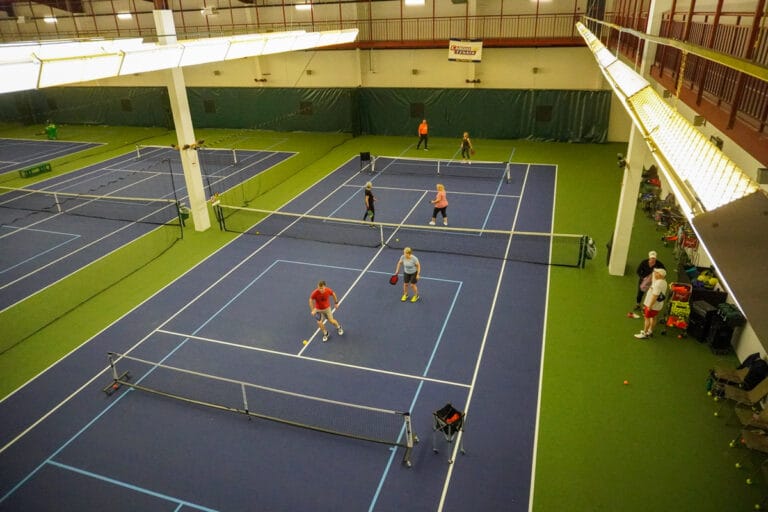 adults playing pickleball on two courts at CRFC