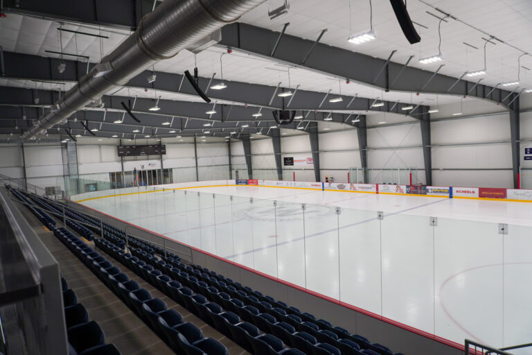 wide angle view of indoor ice arena with bleachers