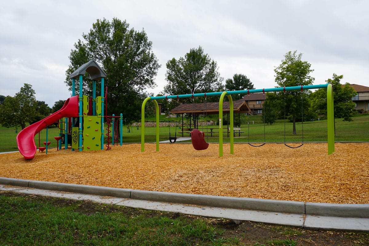 green, red, and blue playground with shelter in the background at Duemeland Park