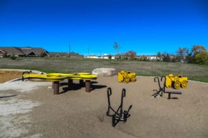 yellow and black playground equipment at Normandy Park including sand table and sand diggers