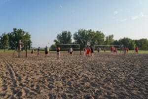 adults playing sand volleyball at Sertoma Park