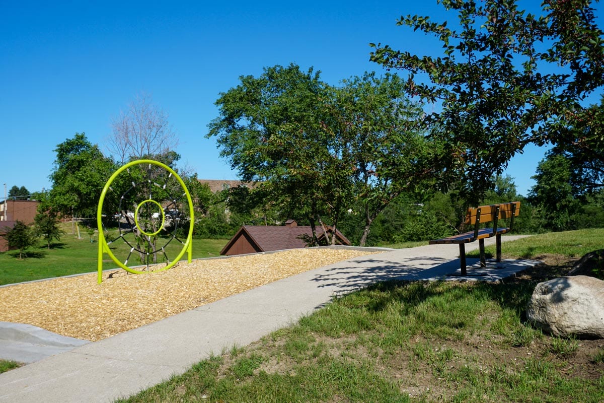 park bench and playground feature along a trail at Zonta Park