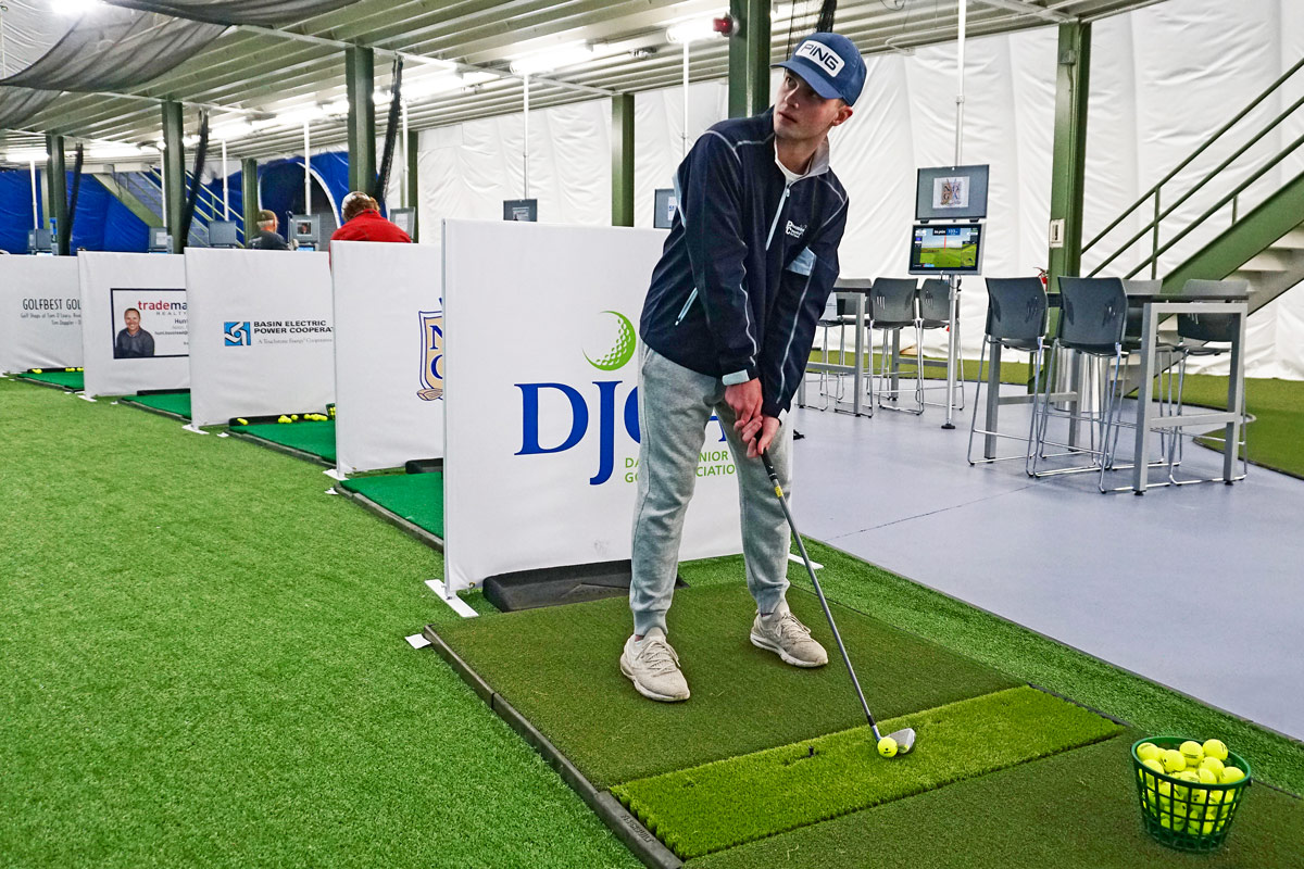 golfer prepares to hit ball at the Toptracer Range at Fore Seasons Center