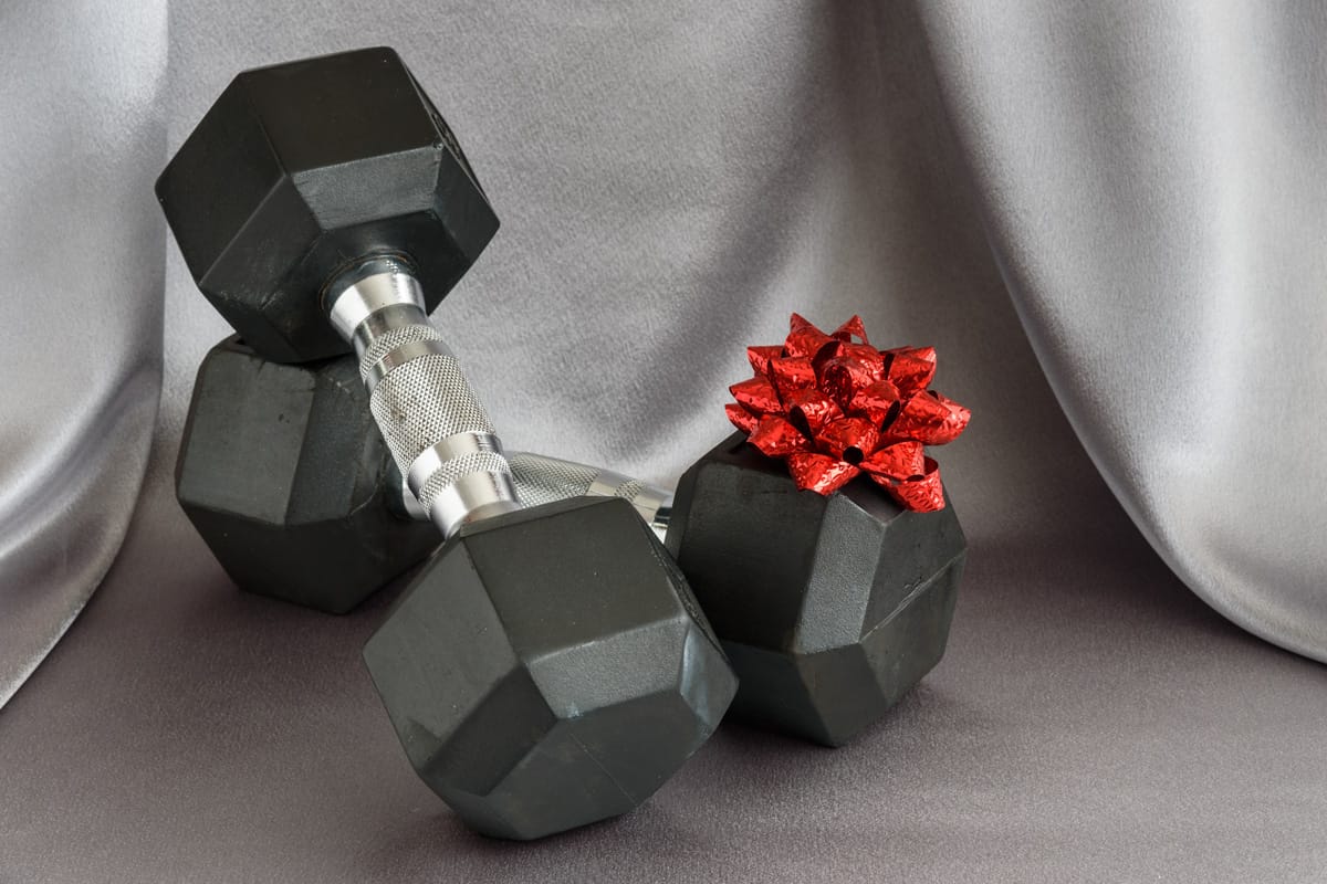 Set of black and silver dumbbells with a red bow on a silver background